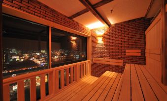 a wooden deck with a view of the city at night , illuminated by street lights at La Vista Hakodate Bay