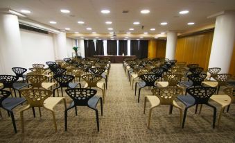 a large conference room with rows of chairs arranged in a semicircle , ready for a meeting or event at The Gate Hotel