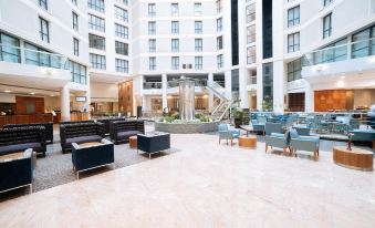 a large hotel lobby with a reception desk , couches , and chairs arranged in an open area at Sofitel London Gatwick
