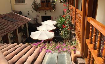 a beautiful courtyard with umbrellas , flowers , and plants , as well as a view of the sky from above at Hotel Midori