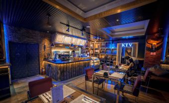 a restaurant with a bar area , where several people are seated and enjoying their meals at ABC Hotel