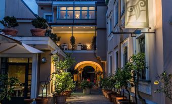 a beautiful house with a balcony and a walkway lined with potted plants leading up to it at Hotel Forum