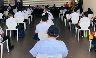 a group of people sitting in white chairs , possibly waiting for an event or meeting at Acantilados