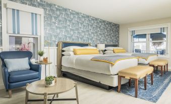 a modern hotel room with two beds , a couch , and a small table , all decorated in blue and yellow colors at Danfords Hotel & Marina