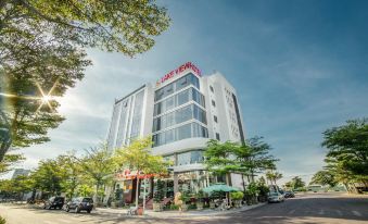 "a large white building with the sign "" cafe 1 2 4 "" on top , surrounded by trees and other buildings in a city setting" at Lake View Hotel