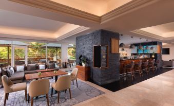 a modern bar with stone walls , wooden furniture , and large windows , surrounded by comfortable seating areas at Lisbon Marriott Hotel