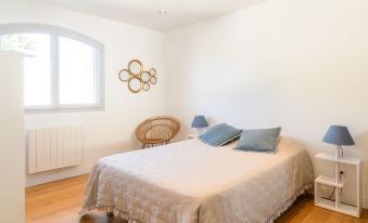 a white bedroom with a large bed , a dresser , and a window overlooking a courtyard at Dade
