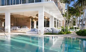 a large white house with a swimming pool in the backyard , surrounded by lush greenery at Grand Beach Hotel Bay Harbor