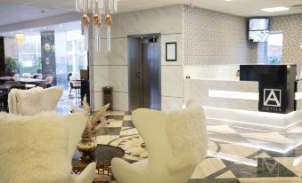 a luxurious hotel lobby with white marble walls , a marble floor , and a gold chandelier at A Hotels Glostrup