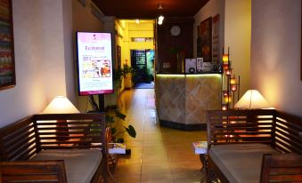 a hallway with a reception desk and chairs , featuring a digital sign on the wall at Discovery Inn