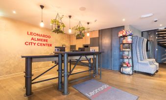 a modern office space with a wooden floor , wooden furniture , and a sign on the wall at Leonardo Hotel Almere City Center