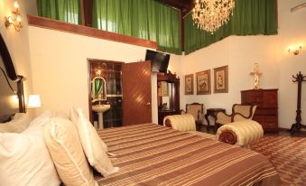 a luxurious hotel room with two beds , a couch , and a tv , decorated with green curtains and a chandelier at Hotel Luna