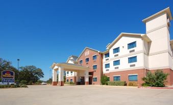 a large hotel with a red and white facade is shown from the side , featuring a covered entrance at Franklin Inn and Suites