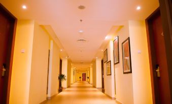 a long hallway with yellow walls and a ceiling lined with framed pictures on the walls at Palm Seremban Hotel