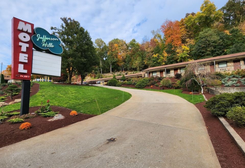 a brick building surrounded by trees , with a path leading up to the entrance of the building at Jefferson Hills Motel