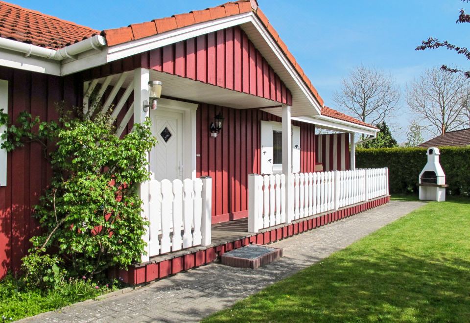 a red and white house surrounded by green grass , with a pathway leading up to the front door at Martin