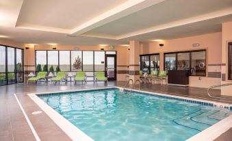 an indoor swimming pool with a diving board , surrounded by lounge chairs and a hot tub at Courtyard Cleveland Elyria