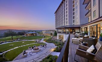 a large hotel with a large courtyard and patio area is shown at sunset at Omni Barton Creek Resort and Spa Austin
