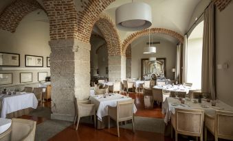 a large dining room with multiple tables and chairs arranged for a group of people to enjoy a meal at Parador de La Granja