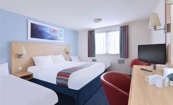 a hotel room with two beds , a desk , and a window , decorated in white and blue colors at Travelodge Ipswich Beacon Hill