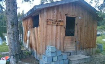 "a wooden cabin with a sign that says "" fish cleaning cooler "" and a blue box in front" at Pine Point Resort