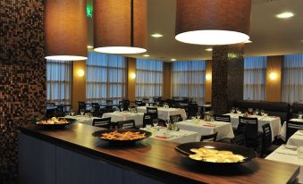 a large dining room with tables and chairs arranged for a group of people to enjoy a meal together at Axis Porto Business & Spa Hotel