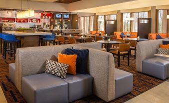 a large , modern hotel lobby with various seating options , including couches and chairs , as well as a bar area at Courtyard Baltimore Hunt Valley