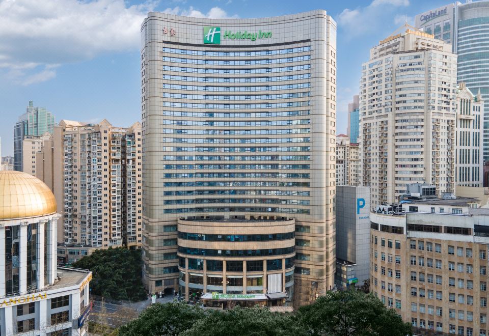 A large building with numerous windows and a central office tower on the upper level at Holiday Inn Shanghai Nanjing Road