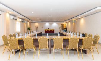 a large conference room with multiple rows of chairs arranged in a semicircle around a long table at RedDoorz Plus @ Paal 2 Manado