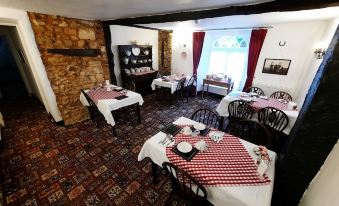 a dining room with tables covered in red and white checkered tablecloths , creating a cozy atmosphere at The White Cottage