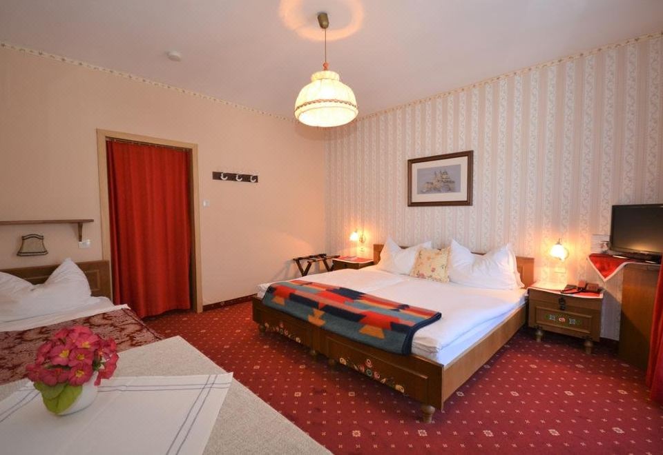 a hotel room with a double bed , a single bed , and a bathroom with a shower at Berghof