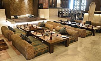 a luxurious hotel lobby with multiple couches , chairs , and tables arranged for guests to enjoy their stay at Hyatt Centric Janakpuri New Delhi