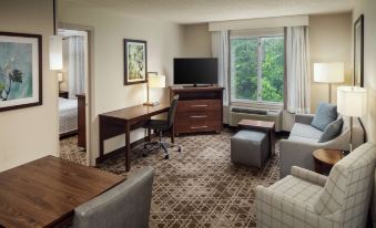 a hotel room with a comfortable bed , a flat - screen tv , a desk , and a couch at Homewood Suites by Hilton Wallingford-Meriden