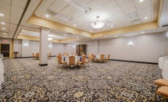 a large , empty banquet hall with multiple tables and chairs set up for a formal event at Crowne Plaza Cleveland Airport