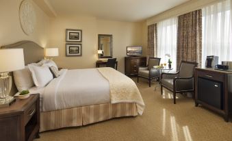 a well - appointed hotel room with a king - sized bed , a chair , a television , and a window at Hotel Santa Barbara