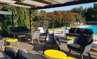 a modern outdoor living area with a variety of furniture , including couches , chairs , and umbrellas at Poisson Rouge