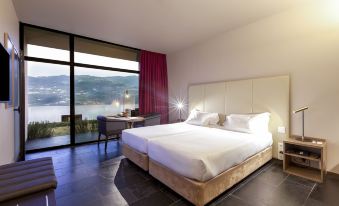 a large bedroom with two beds , one on the left side of the room and the other on the right side at Douro Palace Hotel Resort & Spa