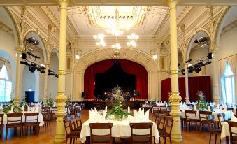 a large banquet hall with multiple tables and chairs set up for a formal event at Hotel Kaiserhof