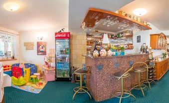 a modern bar with a wooden counter , colorful chairs , and various beverages and snacks on display at Hotel Bella