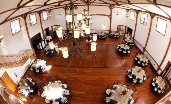 a large dining room with multiple tables and chairs arranged for a formal event , possibly a wedding reception at The Lodges at Gettysburg