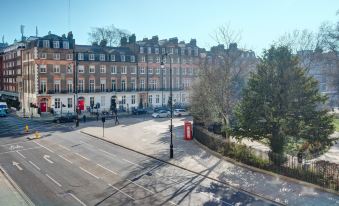 a city street with a red telephone booth located in the middle of the road at President Hotel