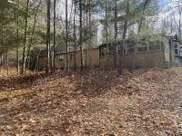 Cozi retreat set in the woods within walking distance of Waubee Lake.