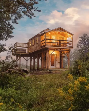 Insanely romantic treehouse perched next to a stream and rolling hills.