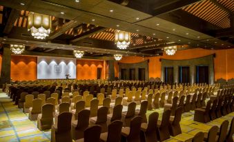 a large , empty conference room with rows of chairs and chandeliers hanging from the ceiling at Legacy Yen Tu - MGallery