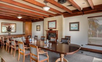 a conference room with a wooden table surrounded by chairs and paintings on the wall at Joondalup Resort