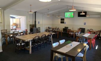 a large dining room with multiple tables and chairs arranged for a group of people to enjoy a meal together at Warrego Hotel Motel Cunnamulla