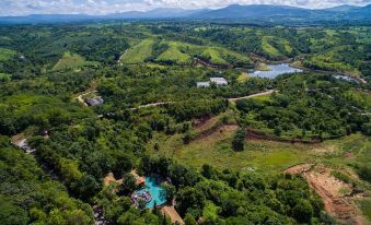 aerial view of a green forest with a large body of water in the distance , surrounded by mountains at Phu Pha Nam Resort