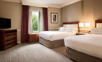 a hotel room with two beds , white linens , and a window view of the outside at Hilton St. Louis Frontenac