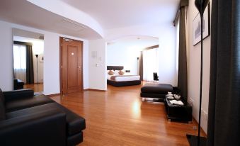 a spacious bedroom with hardwood floors , a large bed , and a tv mounted on the wall at Hotel San Rocco