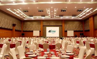 a large banquet hall with numerous round tables and chairs set up for a formal event at Aquarius Boutique Hotel Sampit